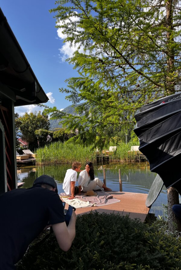 Fotoshooting am See mit Paar auf Steg und Fotografen im Vordergrund