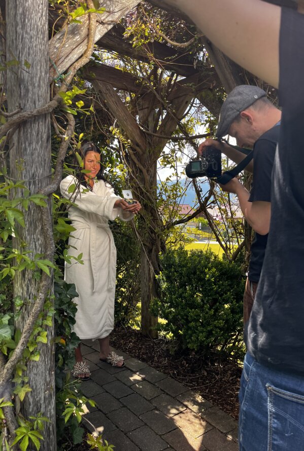 Frau im Bademantel posiert für Fotografen im Garten