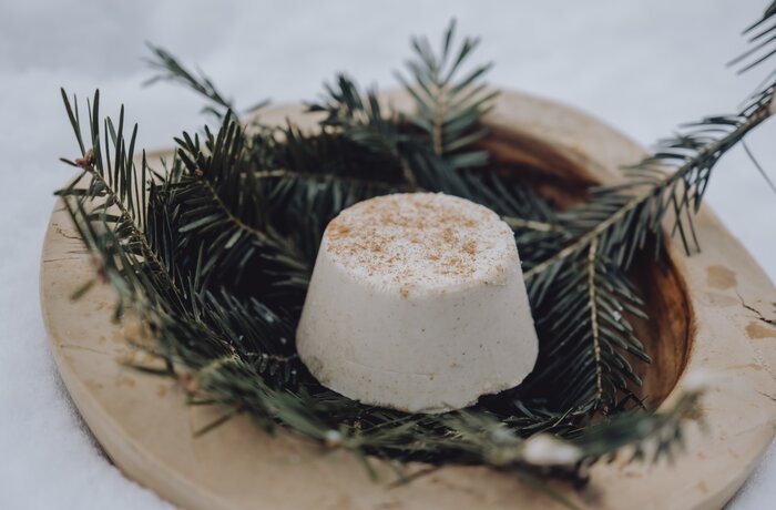 Dessert mit Tannenzweigen auf Holzbrett
