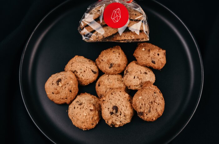 Lebkuchen auf schwarzem Teller, einige lose, andere in Folie mit roter Schleife
