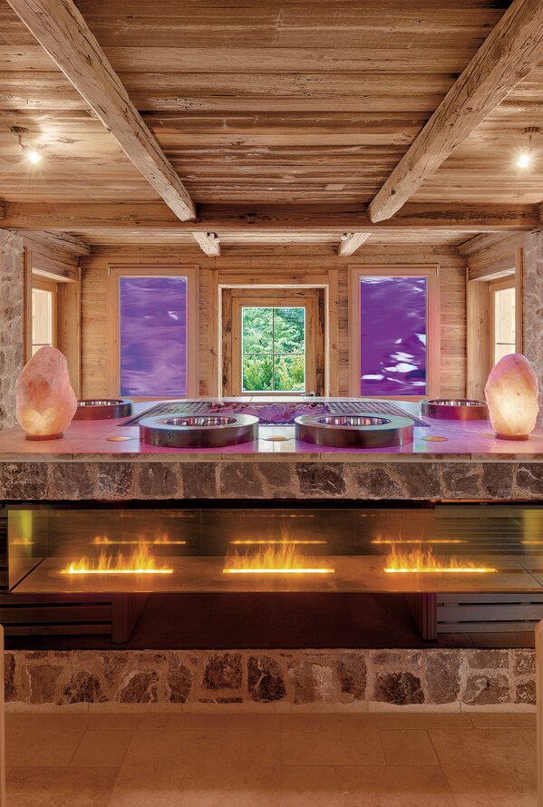 Gemütliche Alpin-Sauna mit warmem Holzdesign und entspannender Kaminatmosphäre.