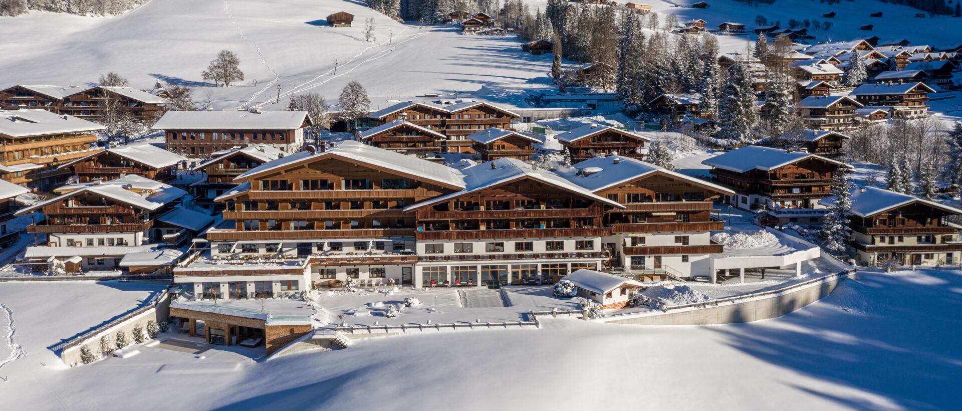 Winterliche Hotelansicht mit schneebedeckten Bergen im Hintergrund