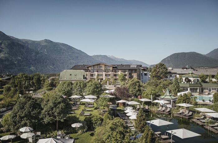 Alpenresort Schwarz mit Pool, Liegen und Bergblick an einem sonnigen Tag