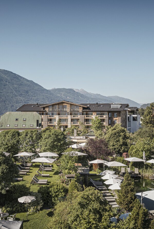 Alpenresort Schwarz mit Pool, Liegen und Bergblick an einem sonnigen Tag