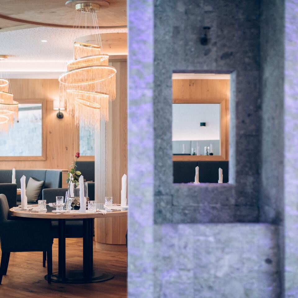 Restaurant-Interieur mit gedecktem Tisch und dekorativer Beleuchtung, Blick durch eine Steinöffnung