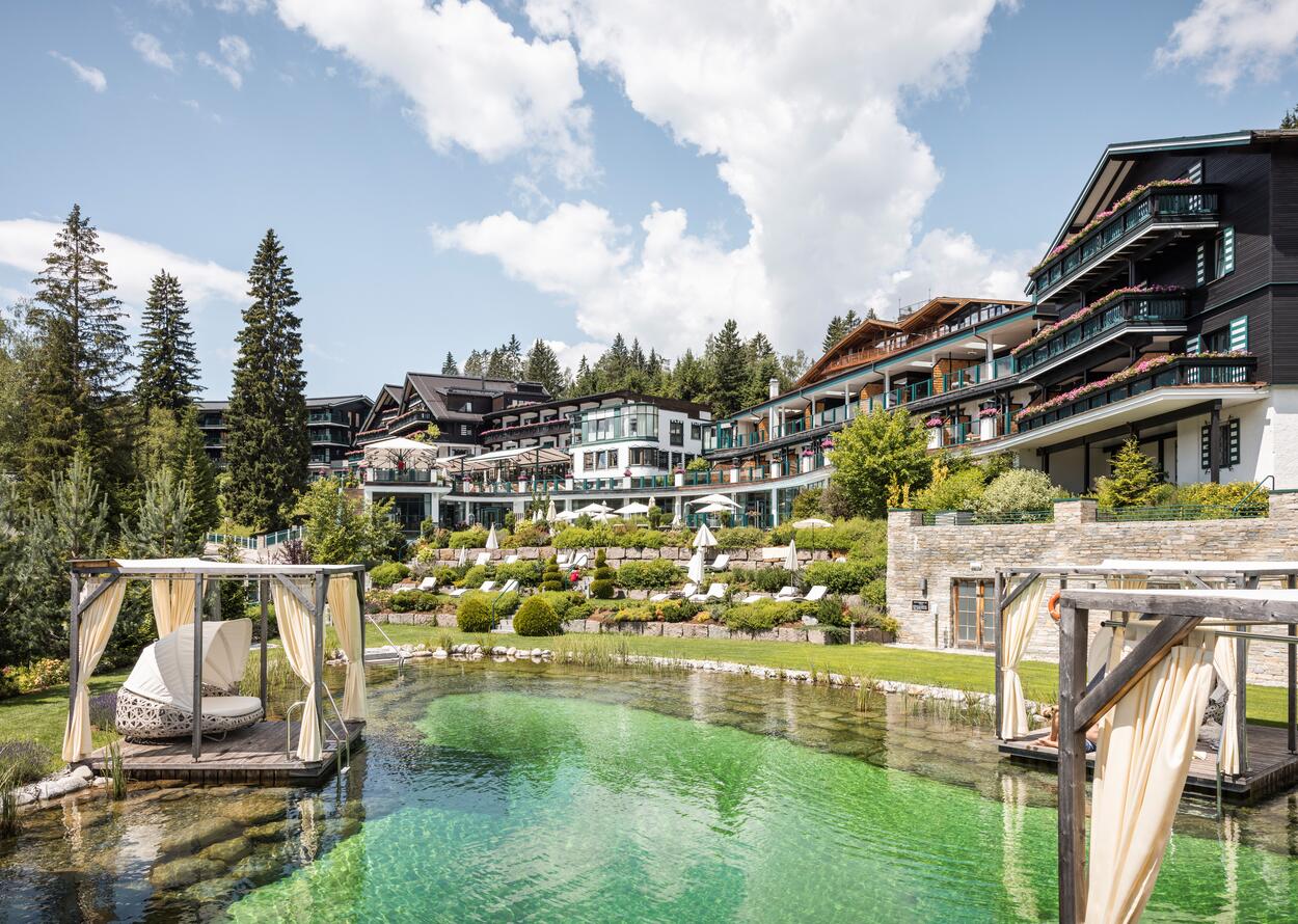 Alpin Resort Sacher Seefeld mit Pool und begrünten Terrassen an einem sonnigen Tag