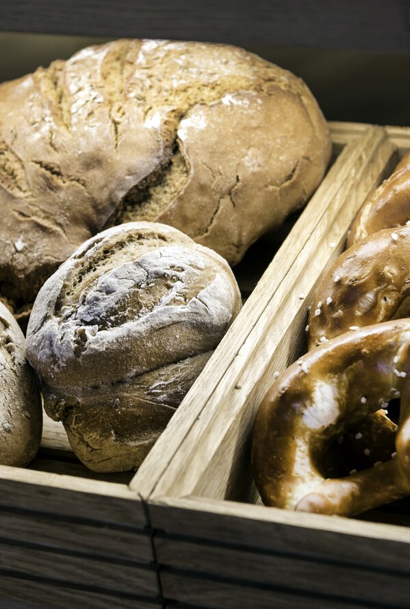 Frisches Brot und Brezeln in Holzkisten auf einem Buffet