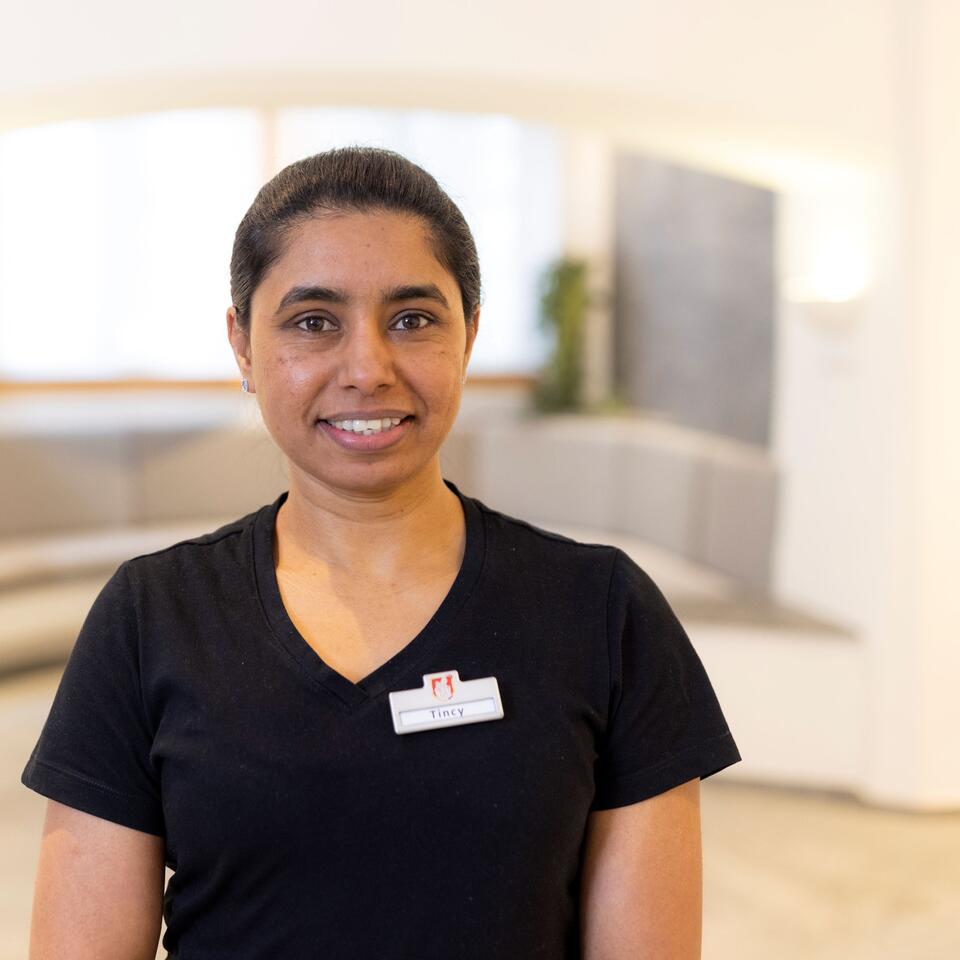 Freundliche Mitarbeiterin im Wellnessbereich mit professioneller Spa-Bekleidung.