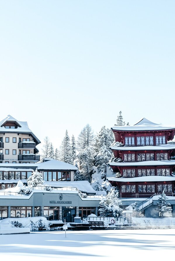 Chinaturm des Hotel Hochschober im Winter mit Schnee und einem Gebäude im asiatischen Stil