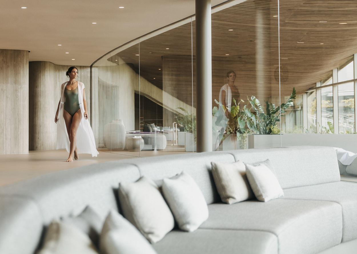 Frau im Badeanzug und Morgenmantel in modernem Interieur