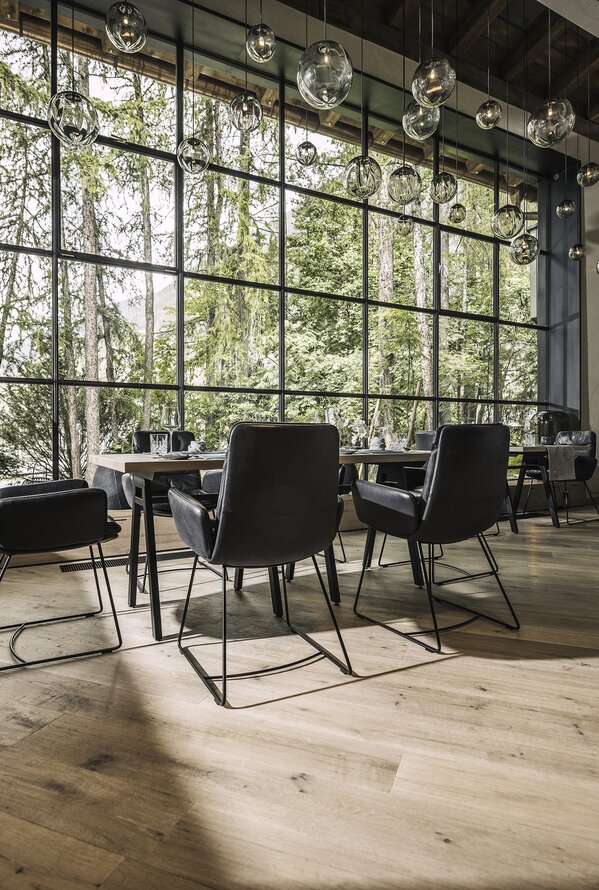 Restaurantraum mit großem Fenster und Blick auf Wald