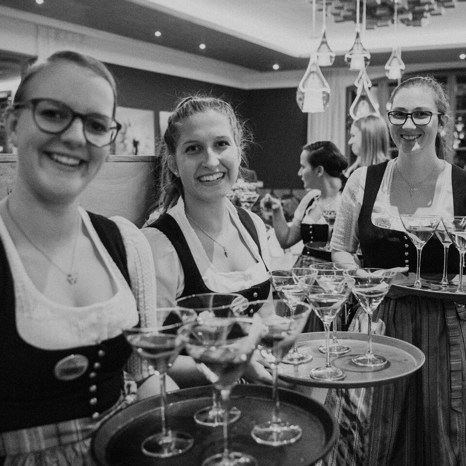 Kellnerinnen im Dirndl mit Tabletts voller Cocktails im Wellnesshotel Nesslerhof