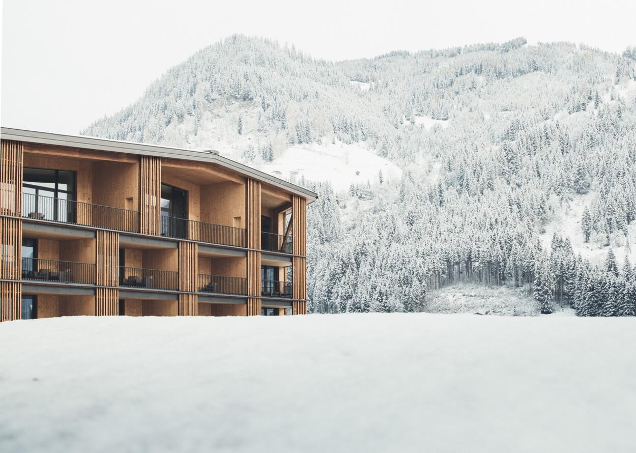 Hotel Nesslerhof vor verschneiter Berglandschaft im Winter