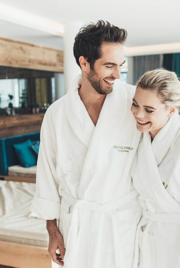 Lächelndes Paar in weißen Bademänteln im Wellnesshotel Nesslerhof