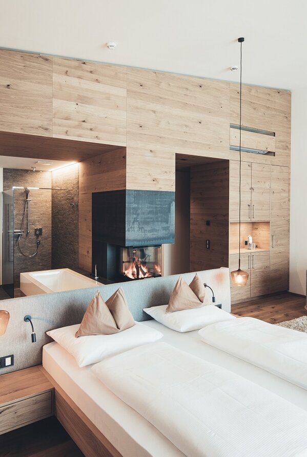 Helles Hotelzimmer mit Doppelbett, Kamin und Sitzecke