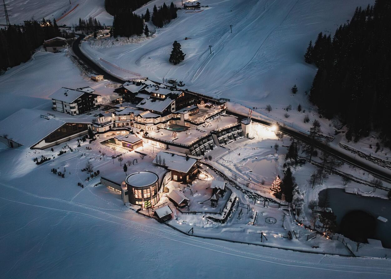 Hotelanlage im Schnee bei Nacht von oben