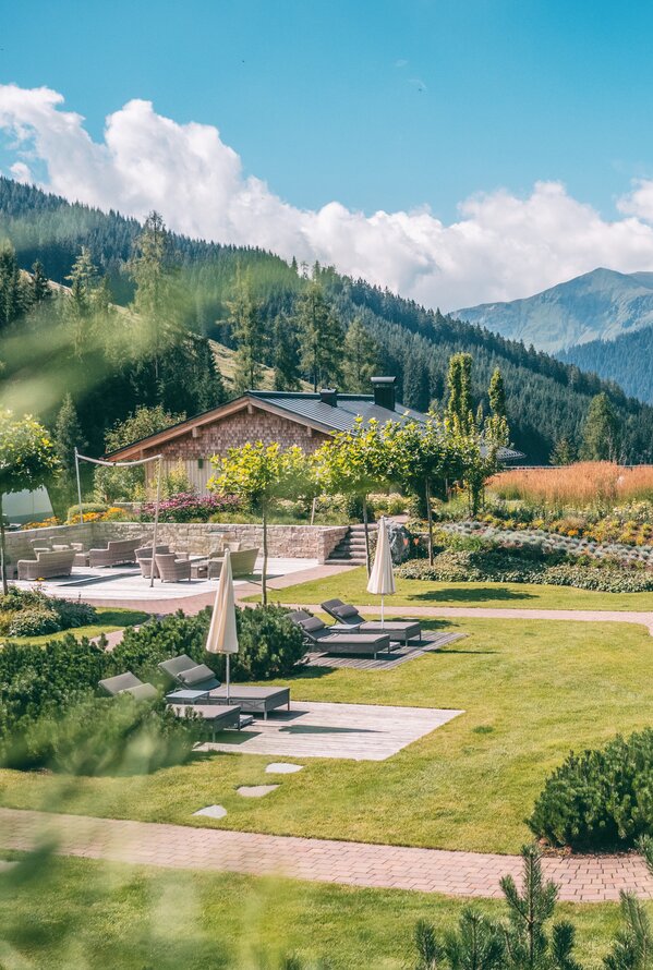 Ruhiger Gartenbereich mit Liegen und Bergpanorama.
