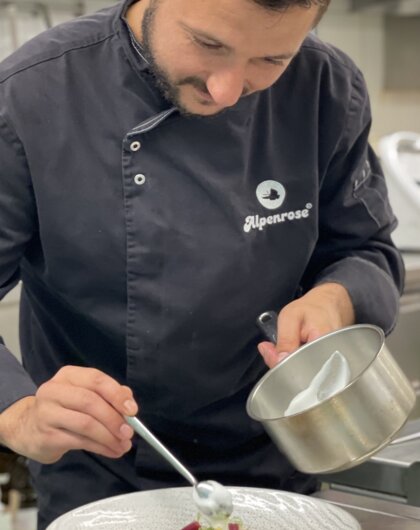 Robert Kuechenchef anrichten Teller mit Topf in der Hand | Best Alpine Wellness Hotel Alpenrose, Tirol