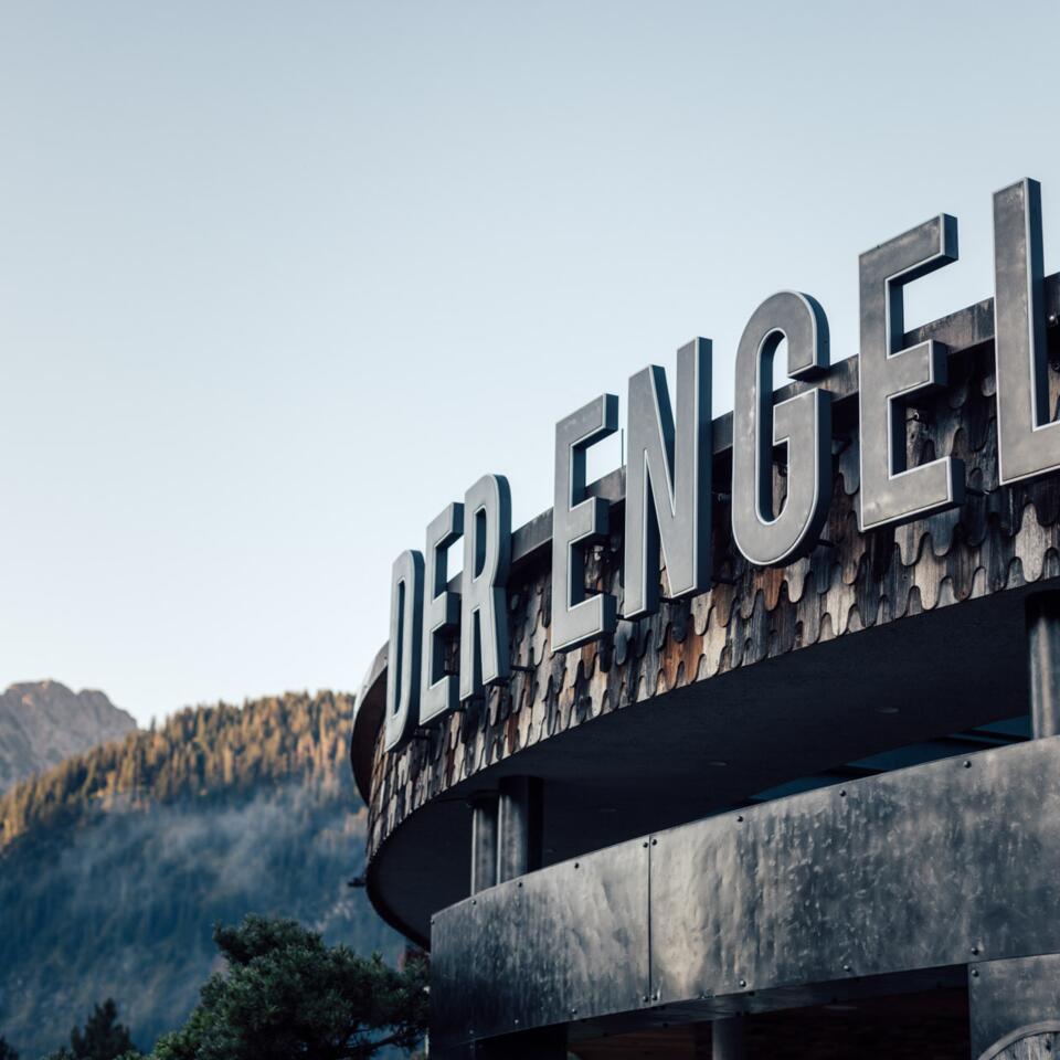 Außenansicht Hotel "Der Engel" mit großem Schriftzug vor Bergkulisse