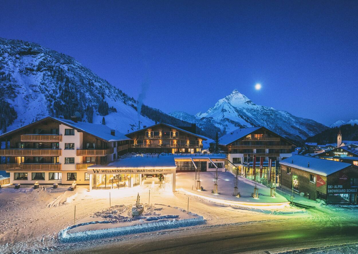 Wellnesshotel Warther Hof im Winter bei Nacht mit Schnee und Bergen im Hintergrund