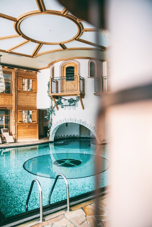 Eleganter Indoor-Pool mit alpinem Charme und ruhiger Wellness-Atmosphäre.