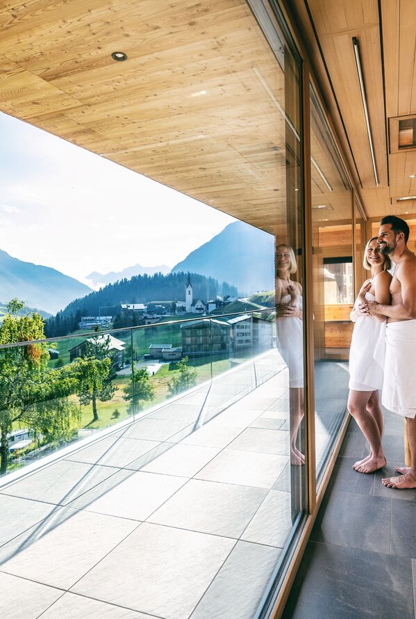 Panorama-Sauna mit beeindruckendem Bergblick und entspannter Wellness-Atmosphäre.