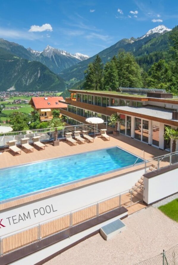 Hotel mit Pool vor Bergkulisse