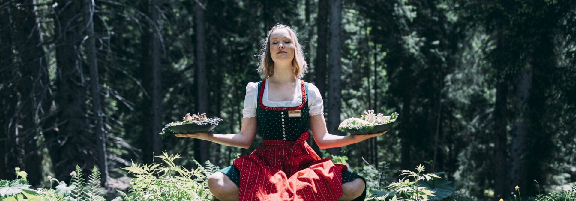 Service|Alpine Work Balance|Frau im Schneidersitz auf Stamm